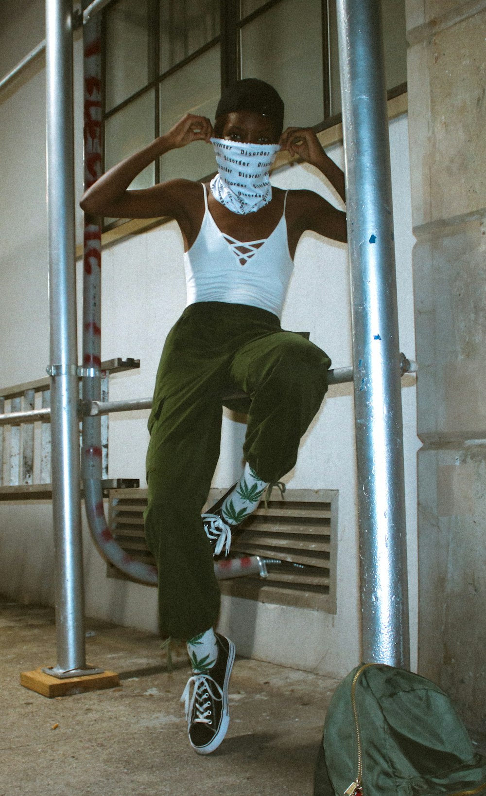 man in blue shirt and green pants climbing on ladder