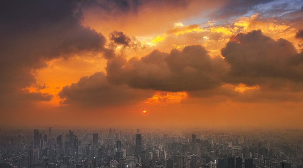 city skyline under orange and gray cloudy sky during sunset