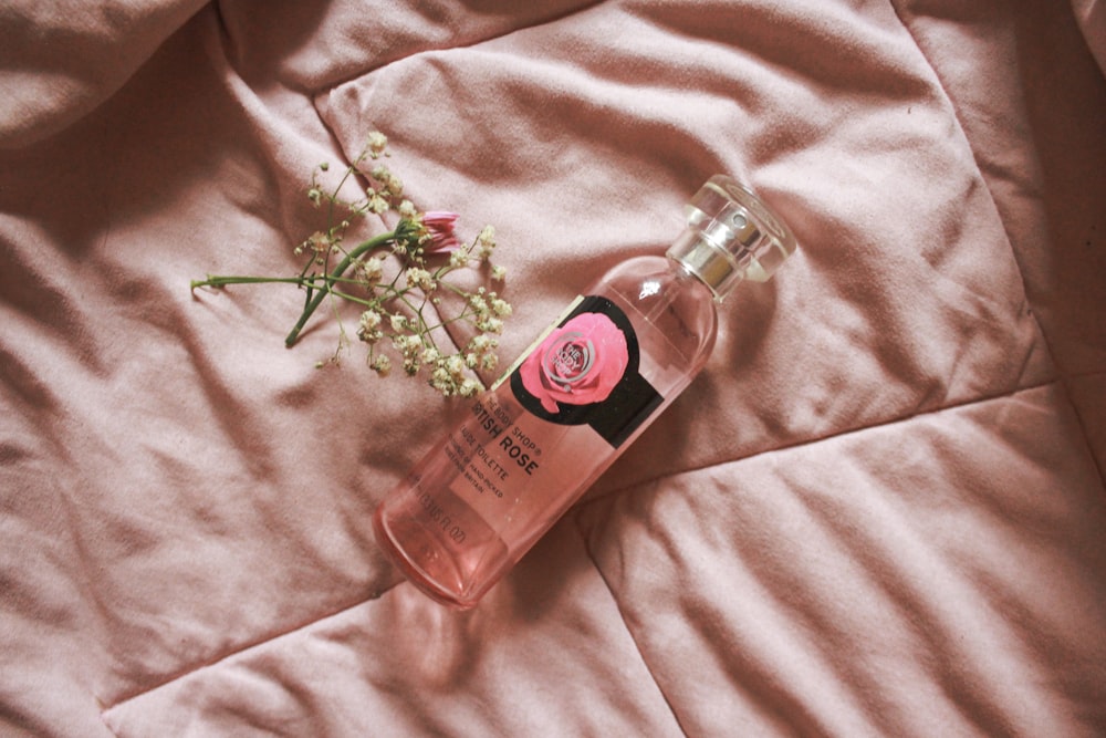 pink perfume bottle on pink textile