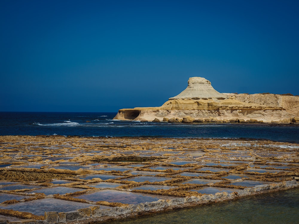 white rock formation on sea under blue sky during daytime