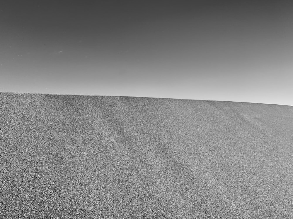 grayscale photo of desert under gray sky