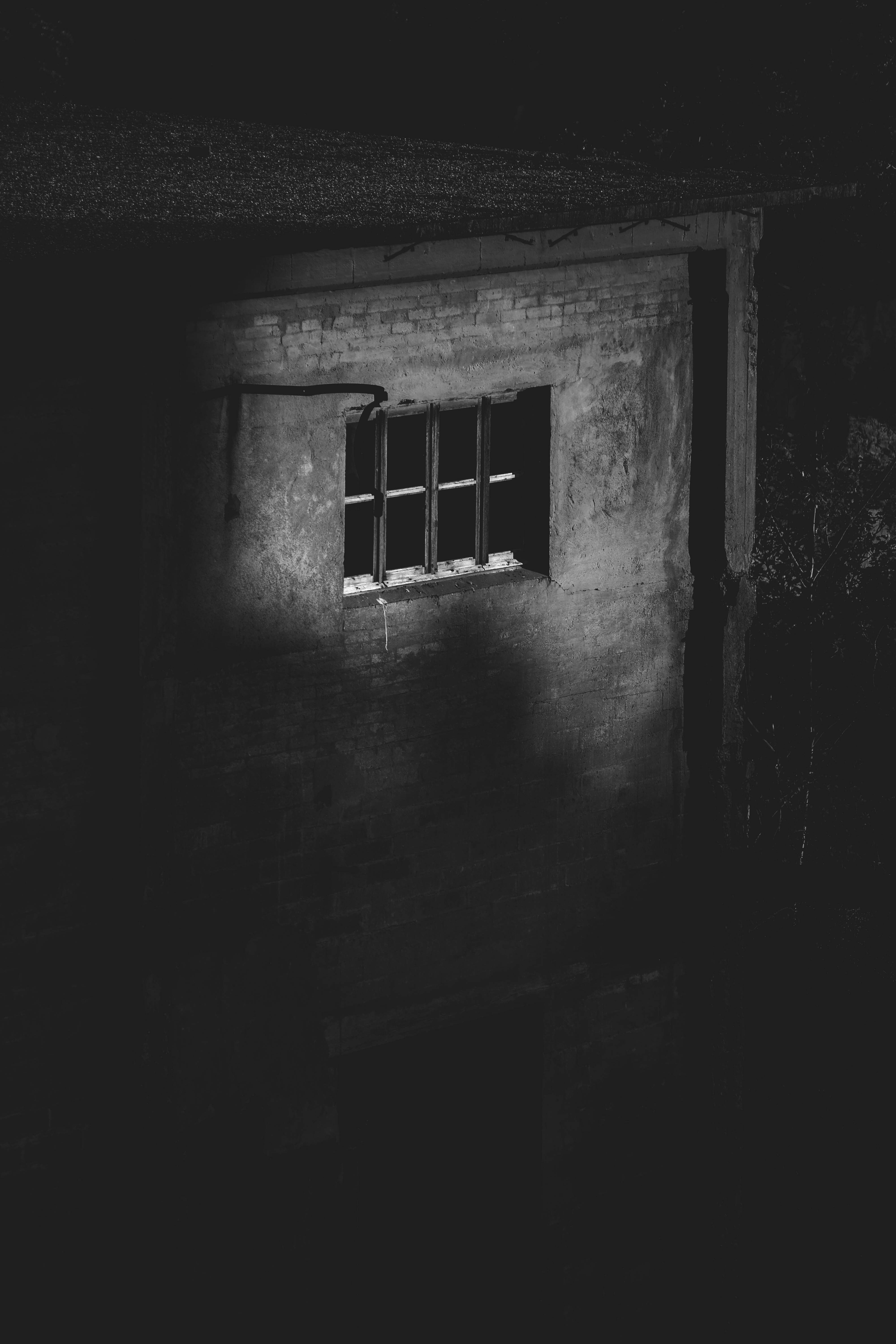 grayscale photo of window in concrete building