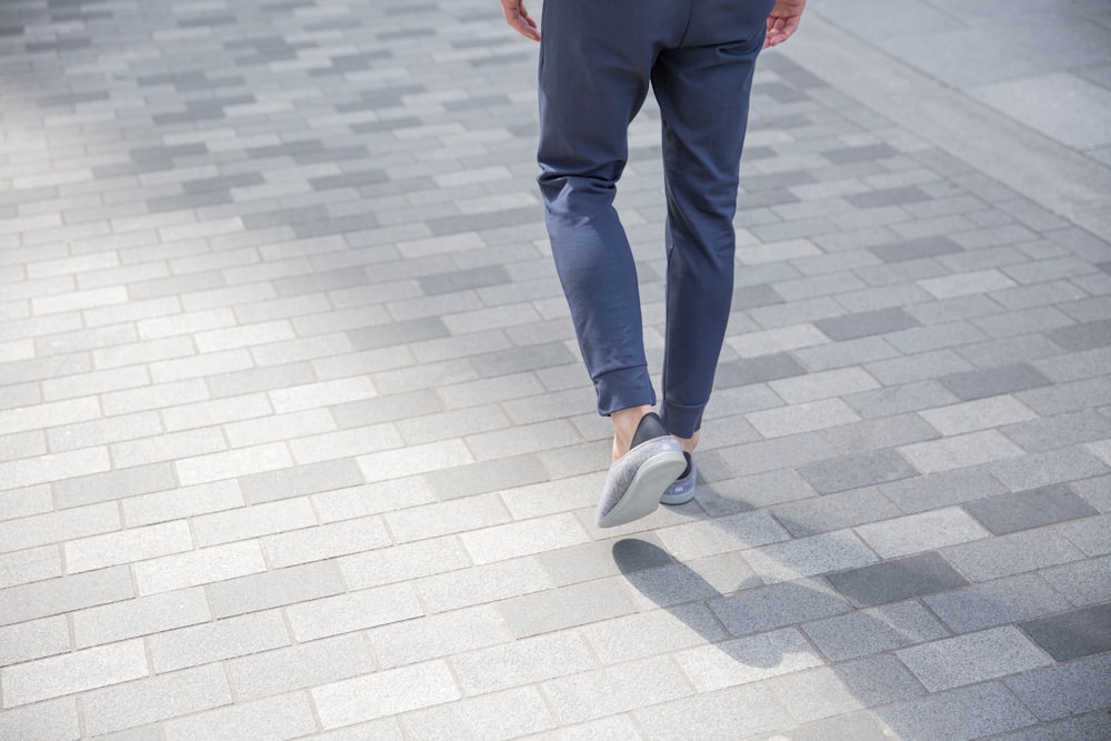 person in black pants and white shoes