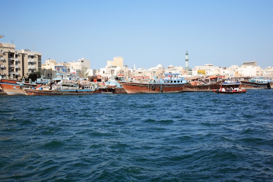 brown boat on sea near city buildings during daytime in Dubai - United Arab Emirates United Arab Emirates