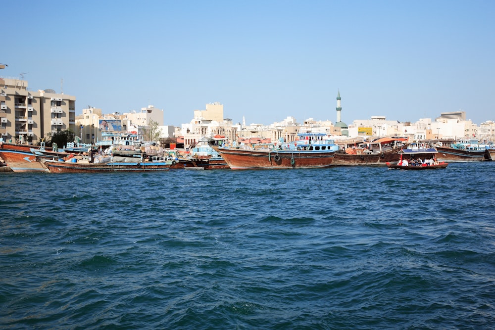 brown boat on sea near city buildings during daytime