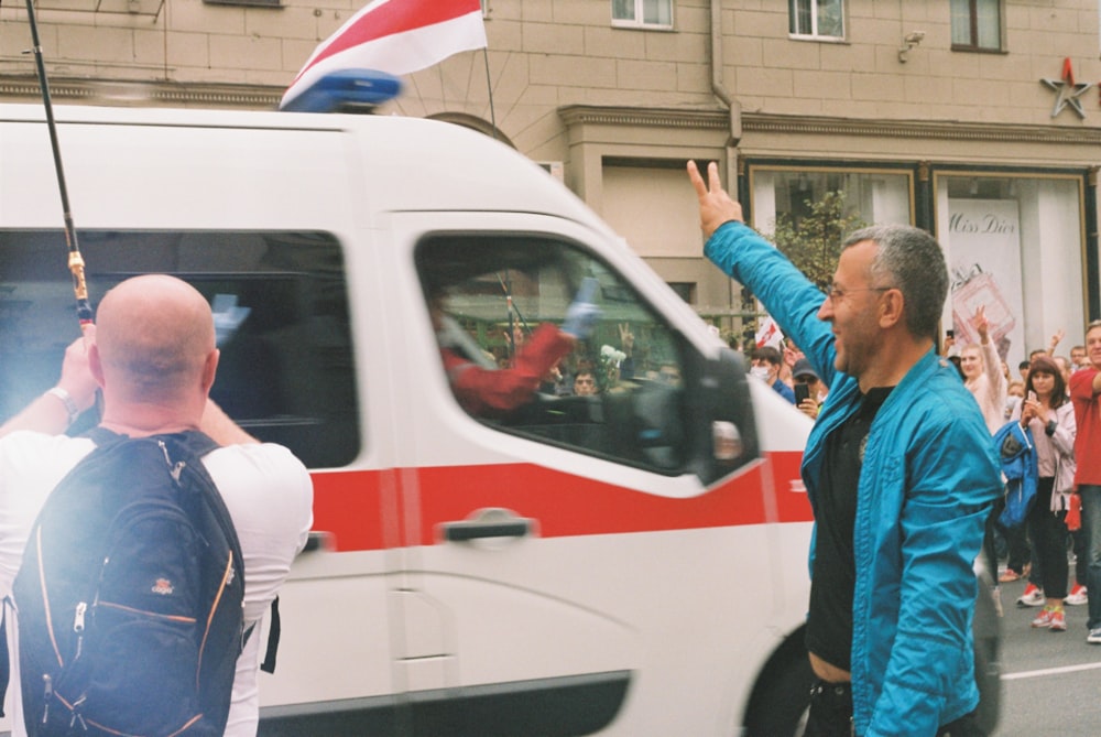 man in blue jacket standing beside man in white shirt