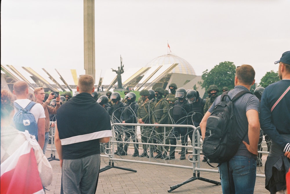 people standing near gray metal fence during daytime