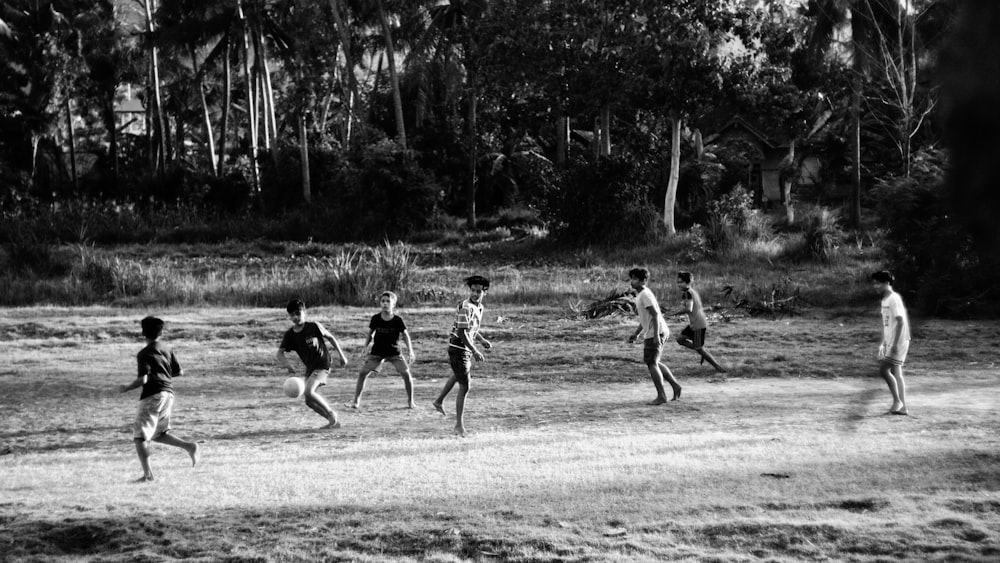 grayscale photo of children playing on field