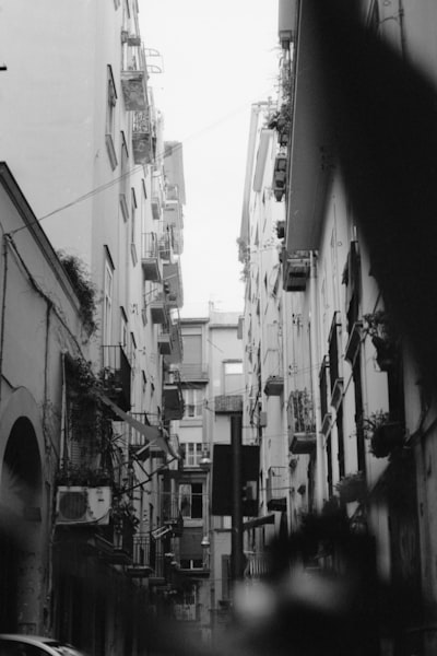 grayscale photo of a street in between buildings