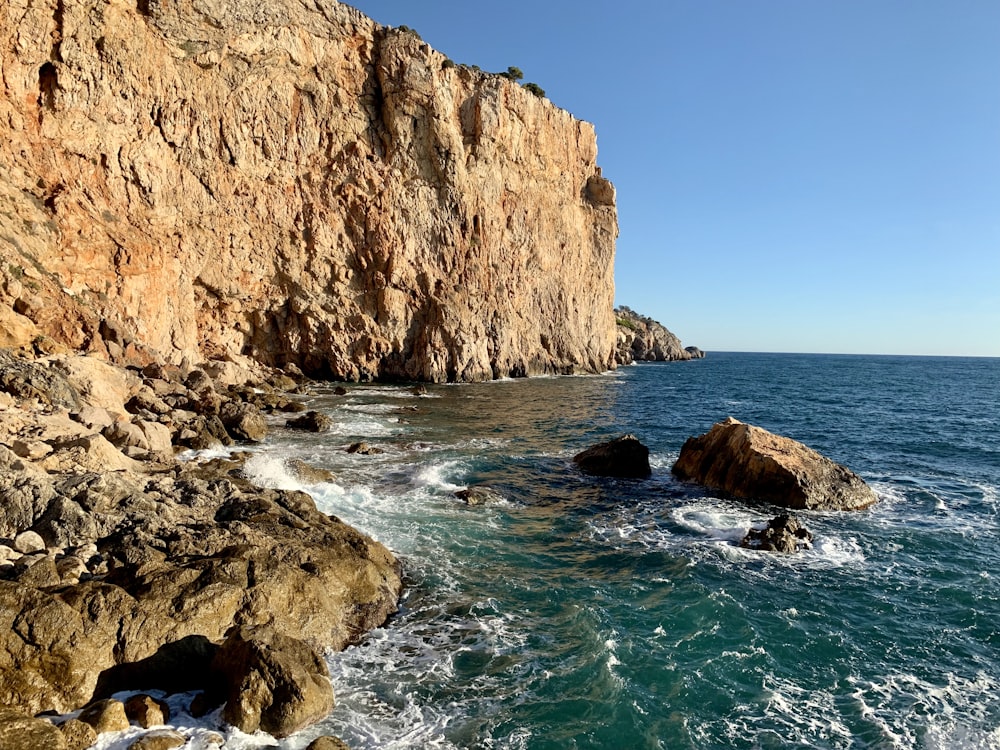 brown rock formation on sea during daytime