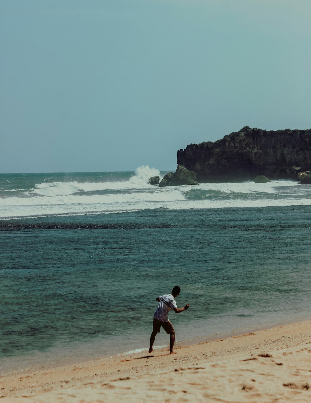 man in black shorts walking on beach during daytime