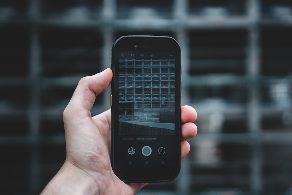 person holding black iphone 4