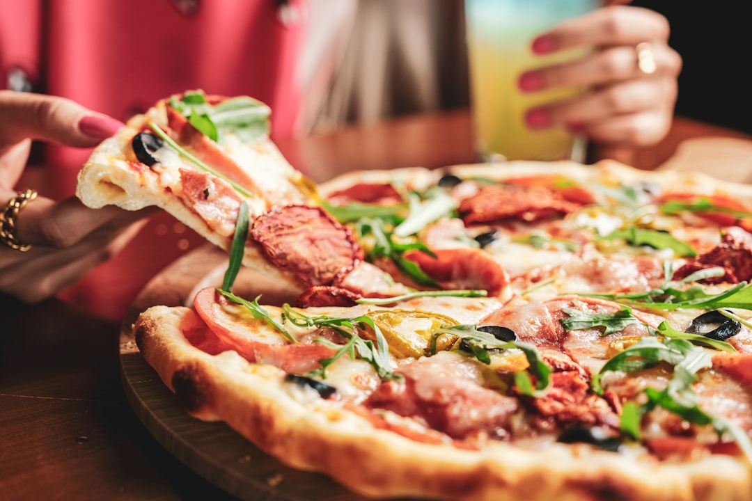 pizza with green leaf on brown wooden table