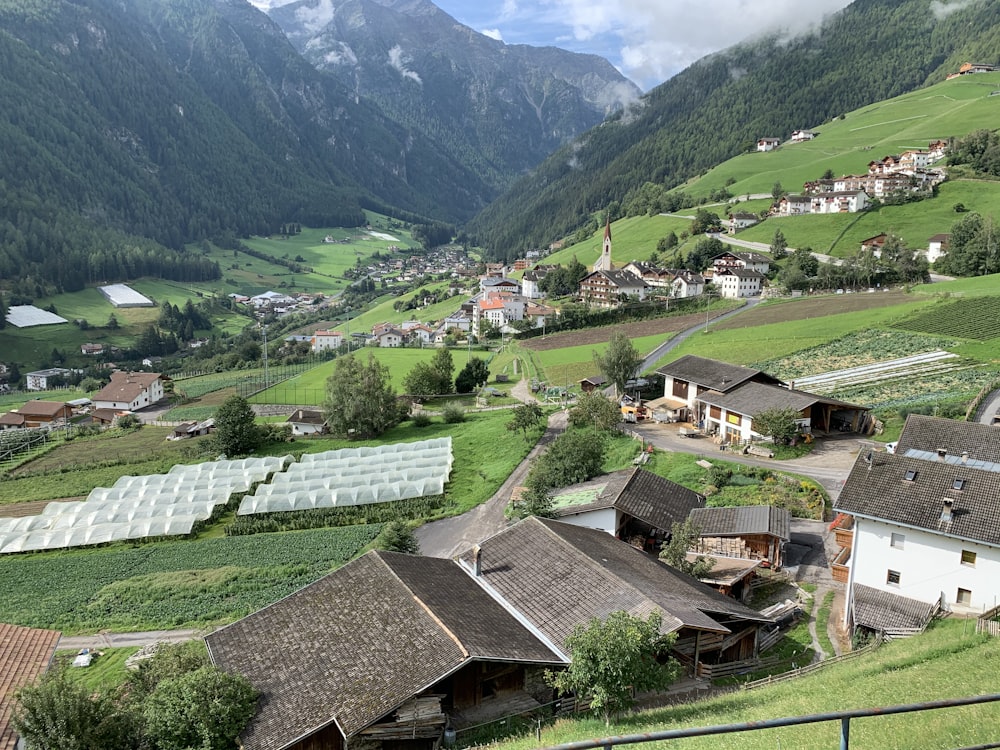 houses on green grass field near mountains during daytime