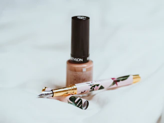 Elegant nails featuring a subtle beige ombré design with delicate gold accents.