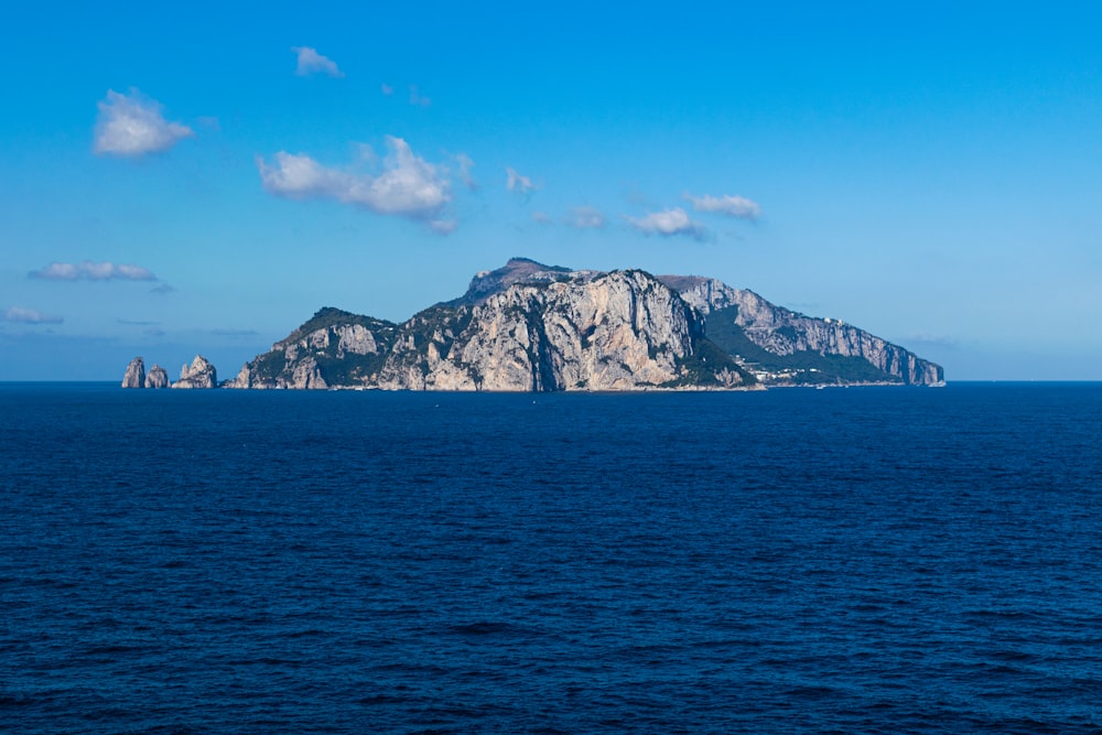 body of water near mountain under blue sky during daytime