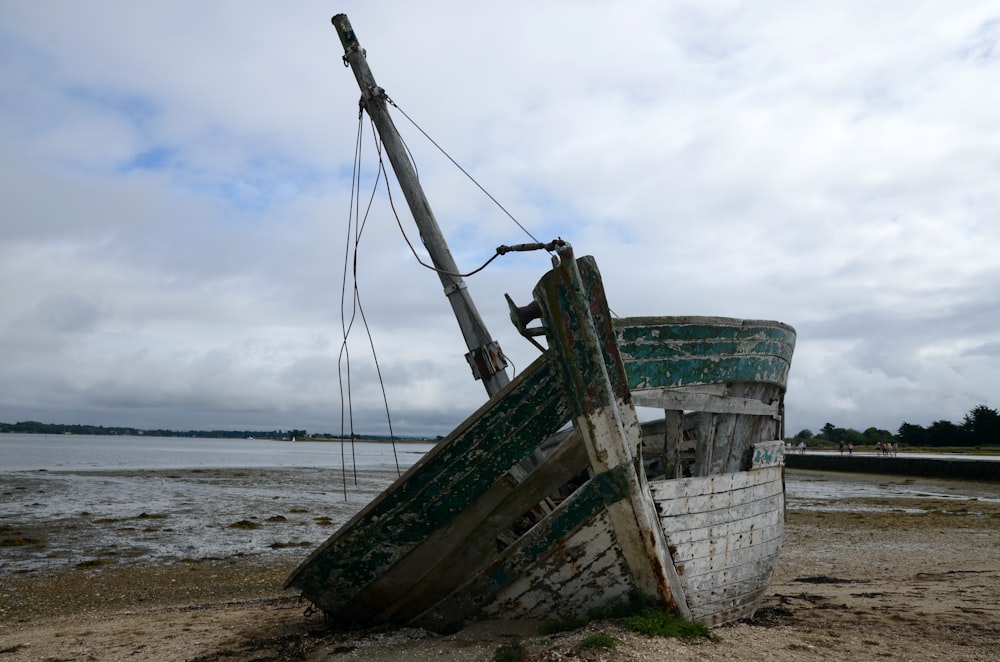 green and white boat on beach during daytime