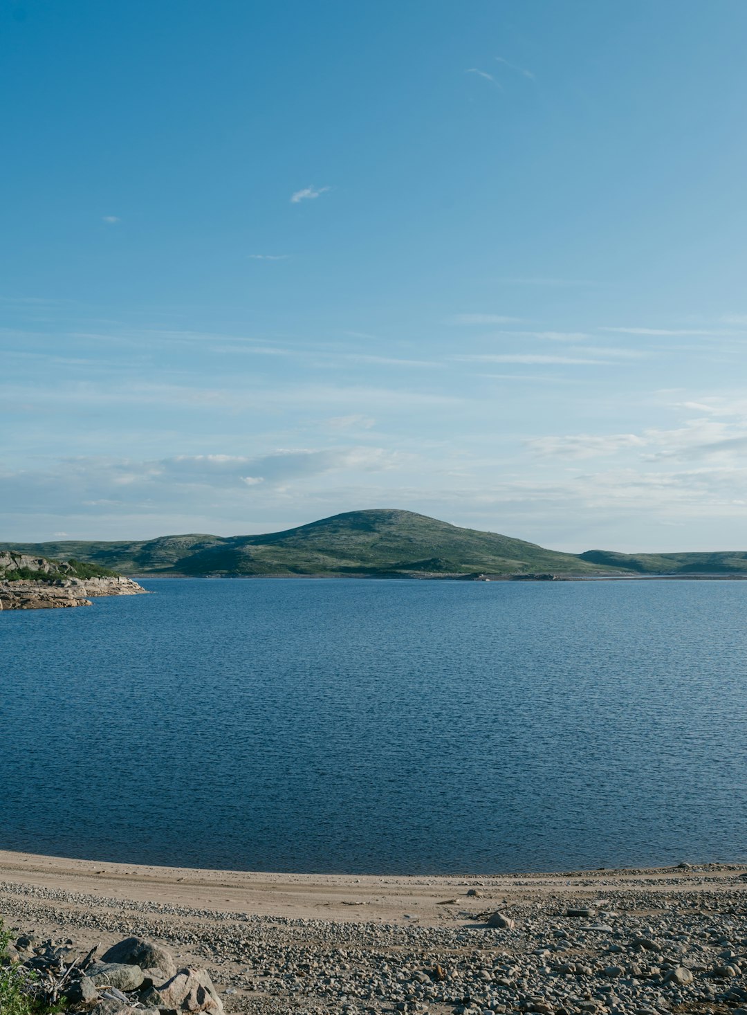 green mountain beside blue sea under blue sky during daytime