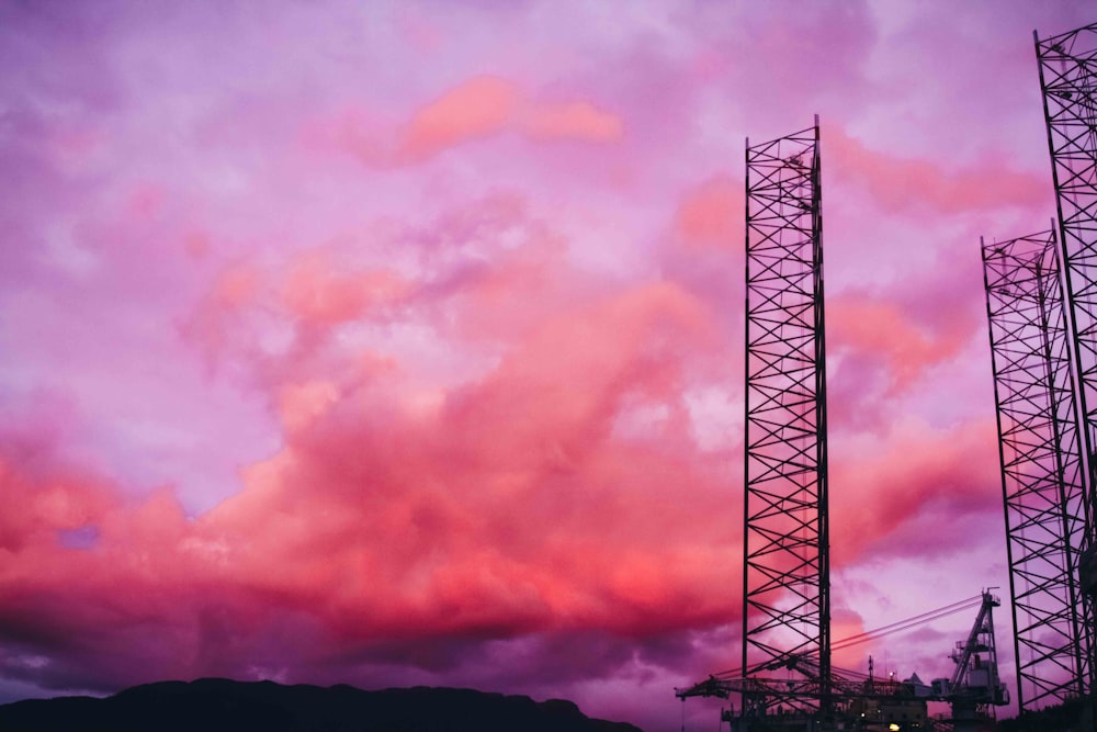 a purple sky with some clouds and a tower