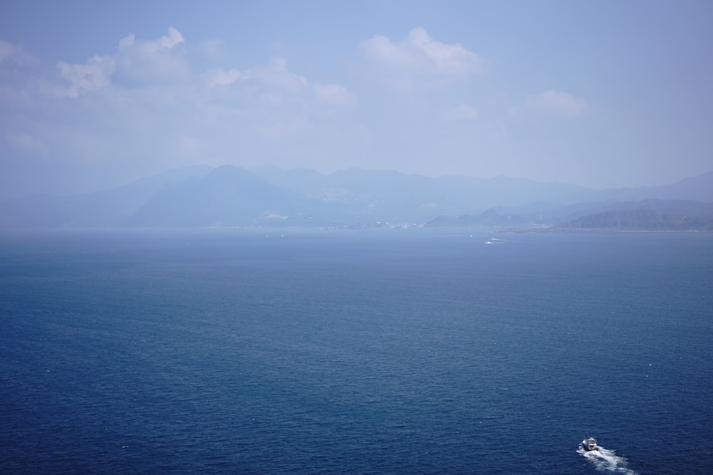 body of water near mountain during daytime