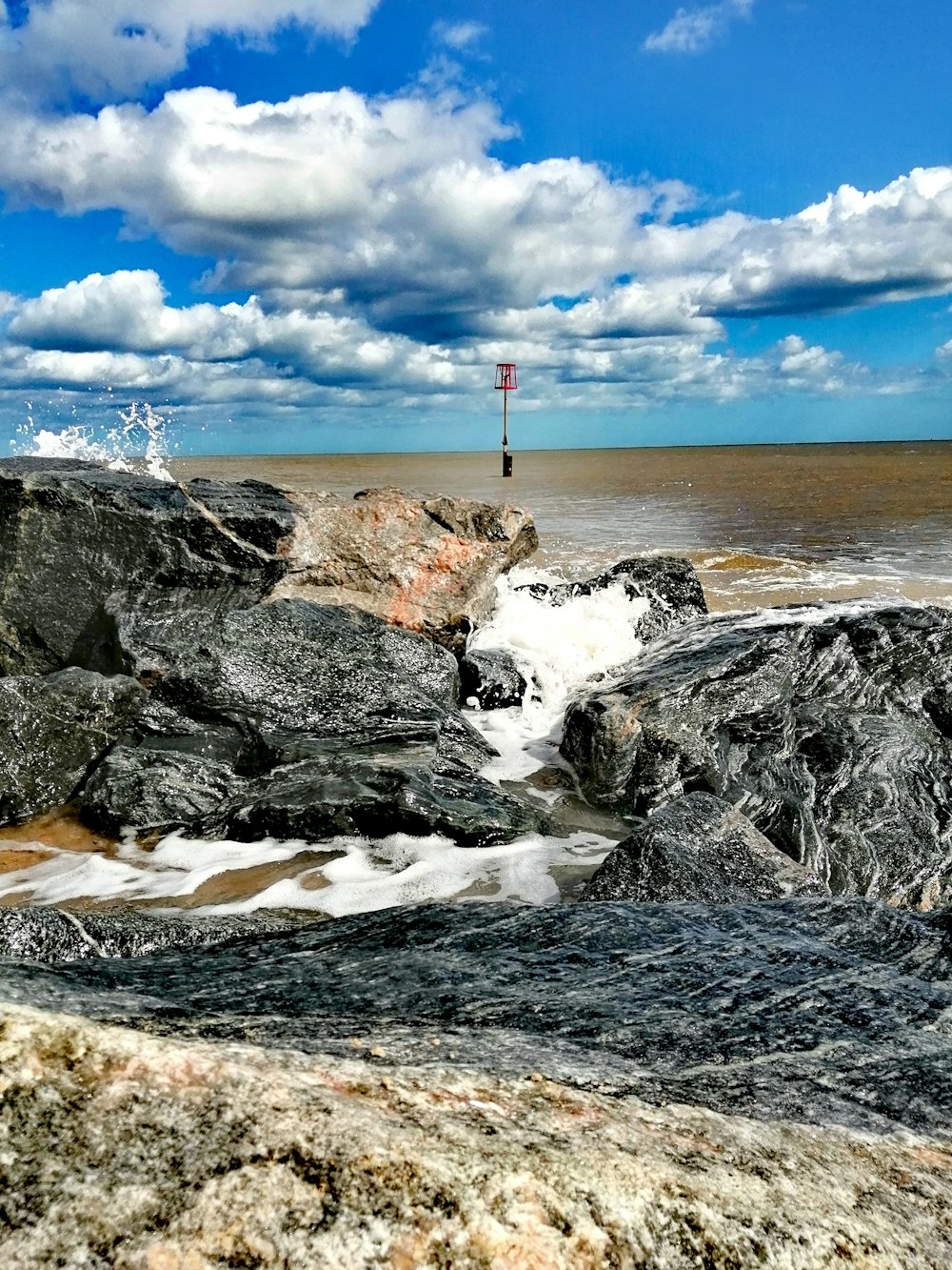 person standing on rock formation near body of water during daytime