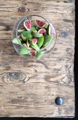 Fresh figs displayed on a wooden table ready for processing.