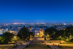 A city skyline viewed from a quiet rooftop garden at dusk.