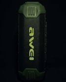 A portable speaker with a rugged, green exterior and a prominent front grille displaying the brand name in a stylized font. The design appears durable and suitable for outdoor use.
