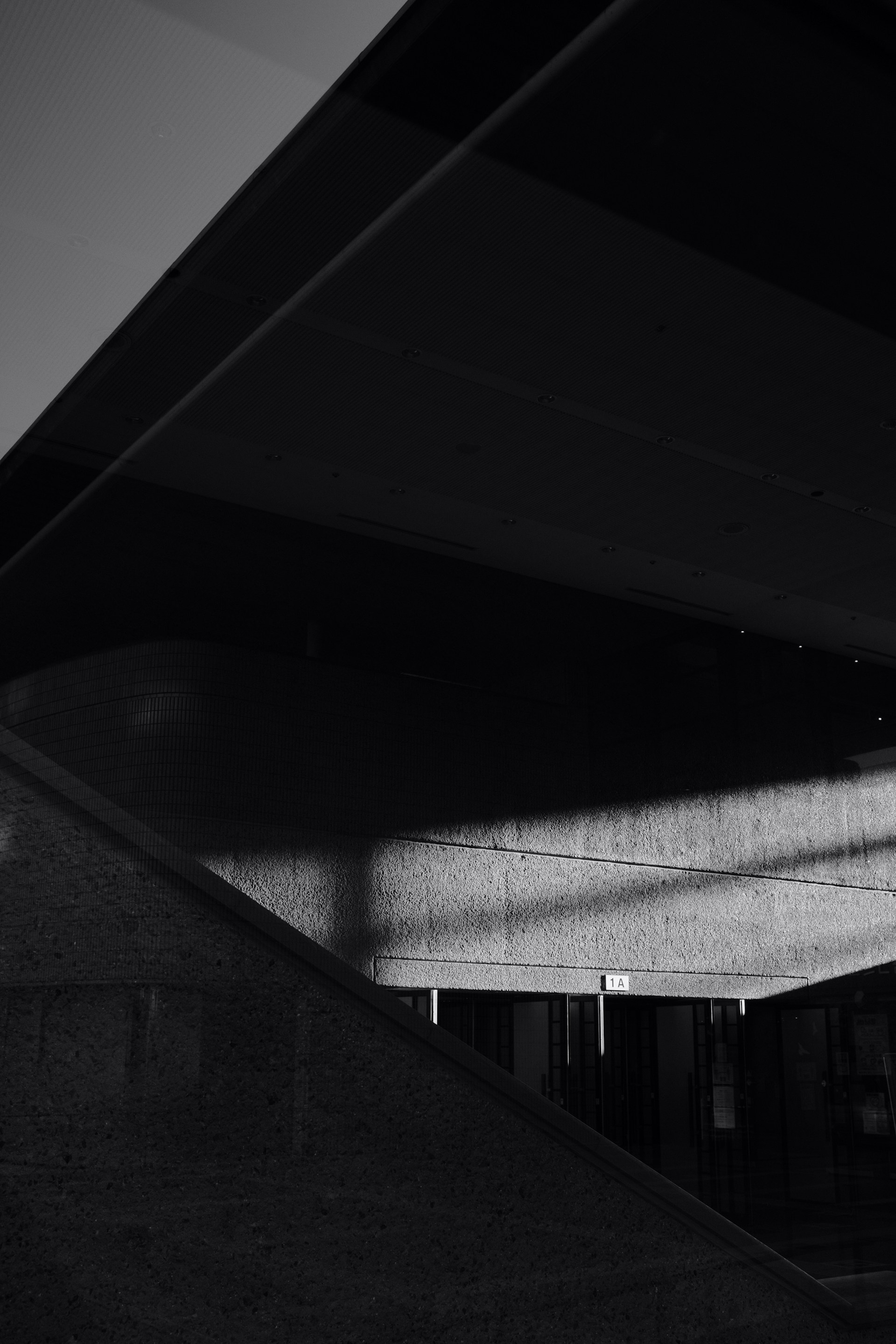 A minimalist urban landscape in monochrome, highlighting geometric lines and shadows.