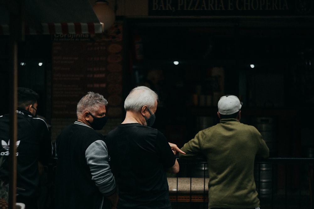 man in black long sleeve shirt standing beside man in black long sleeve shirt