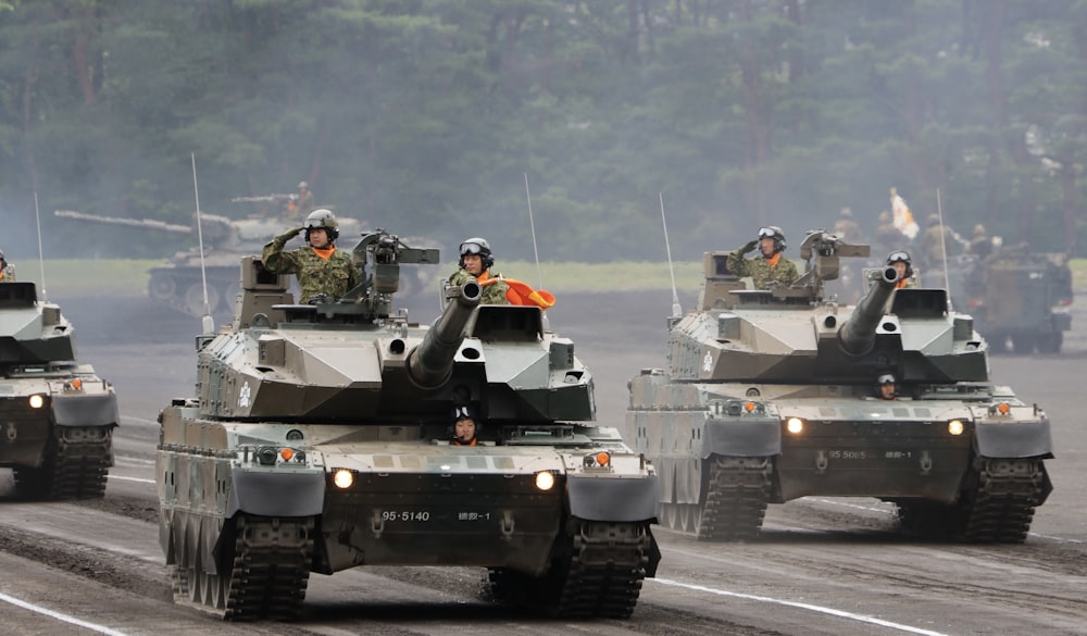 a group of military tanks driving down a road