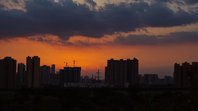 A vibrant cityscape background with a runner silhouette leaping between rooftops at sunset.