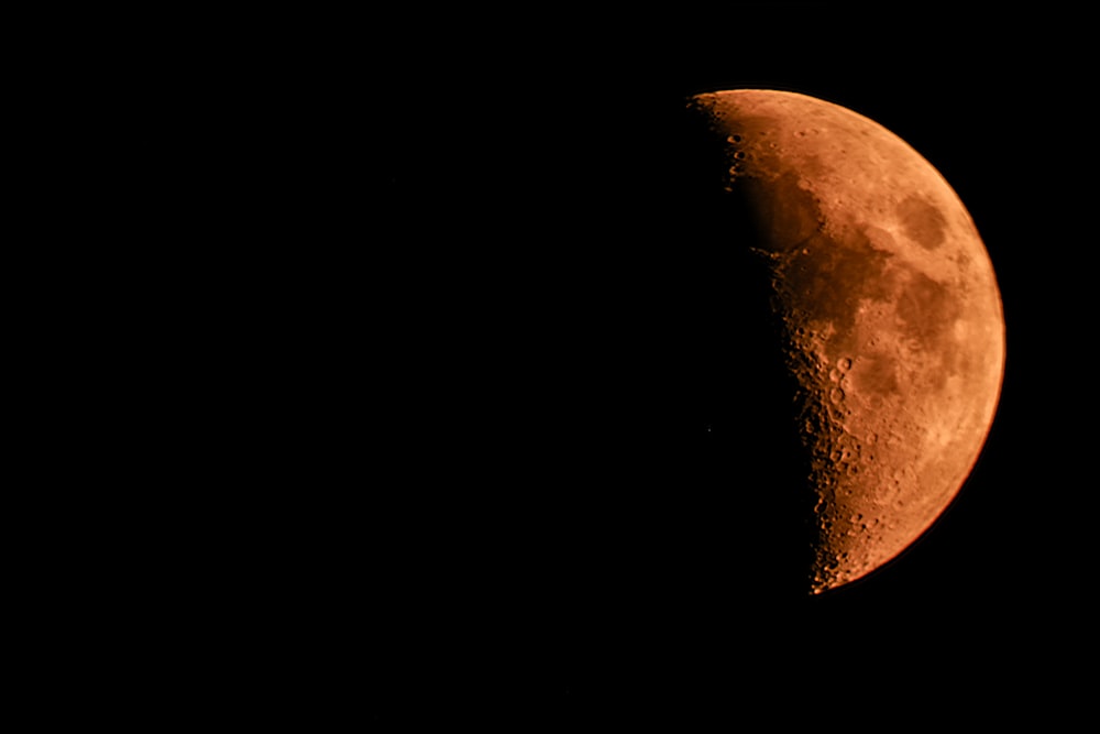 brown moon in dark night sky