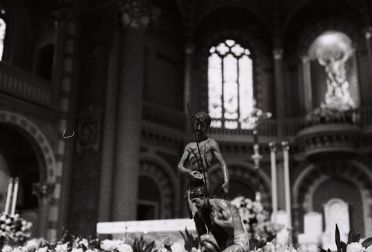 grayscale photo of man playing guitar in Assumption Cathedral Thailand