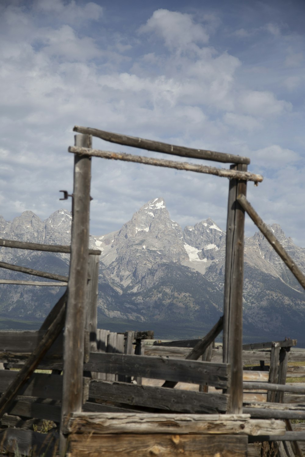 brown wooden frame near snow covered mountain during daytime