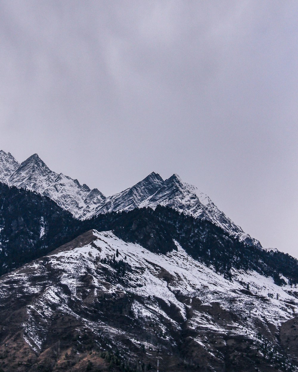 snow covered mountain under cloudy sky during daytime