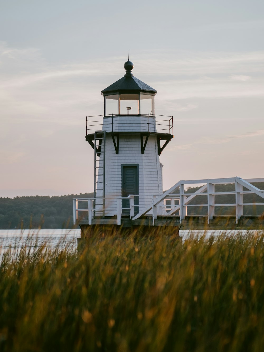 white and black lighthouse near body of water during daytime