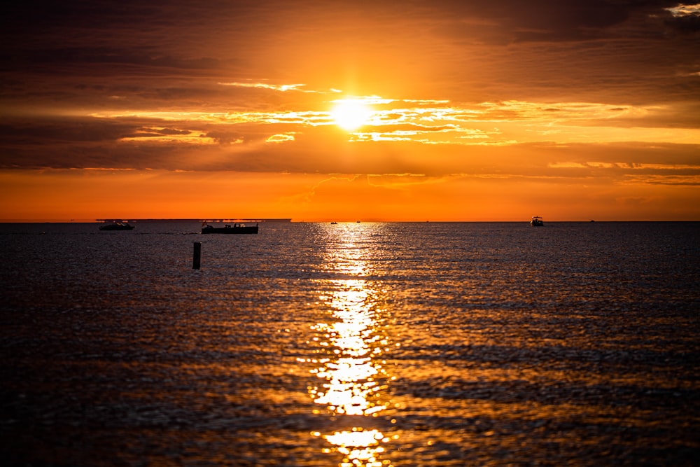 silhouette de personnes sur la mer pendant le coucher du soleil