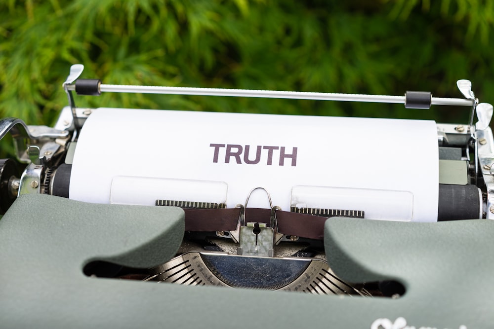 a close up of a typewriter with the word truth on it