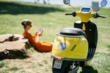 man in orange shirt riding yellow motorcycle during daytime
