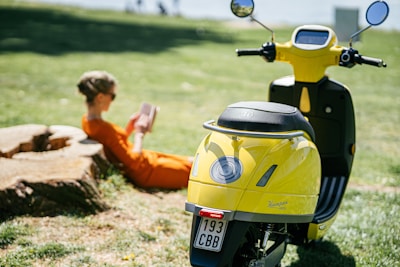 man in orange shirt riding yellow motorcycle during daytime