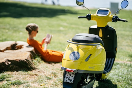man in orange shirt riding yellow motorcycle during daytime
