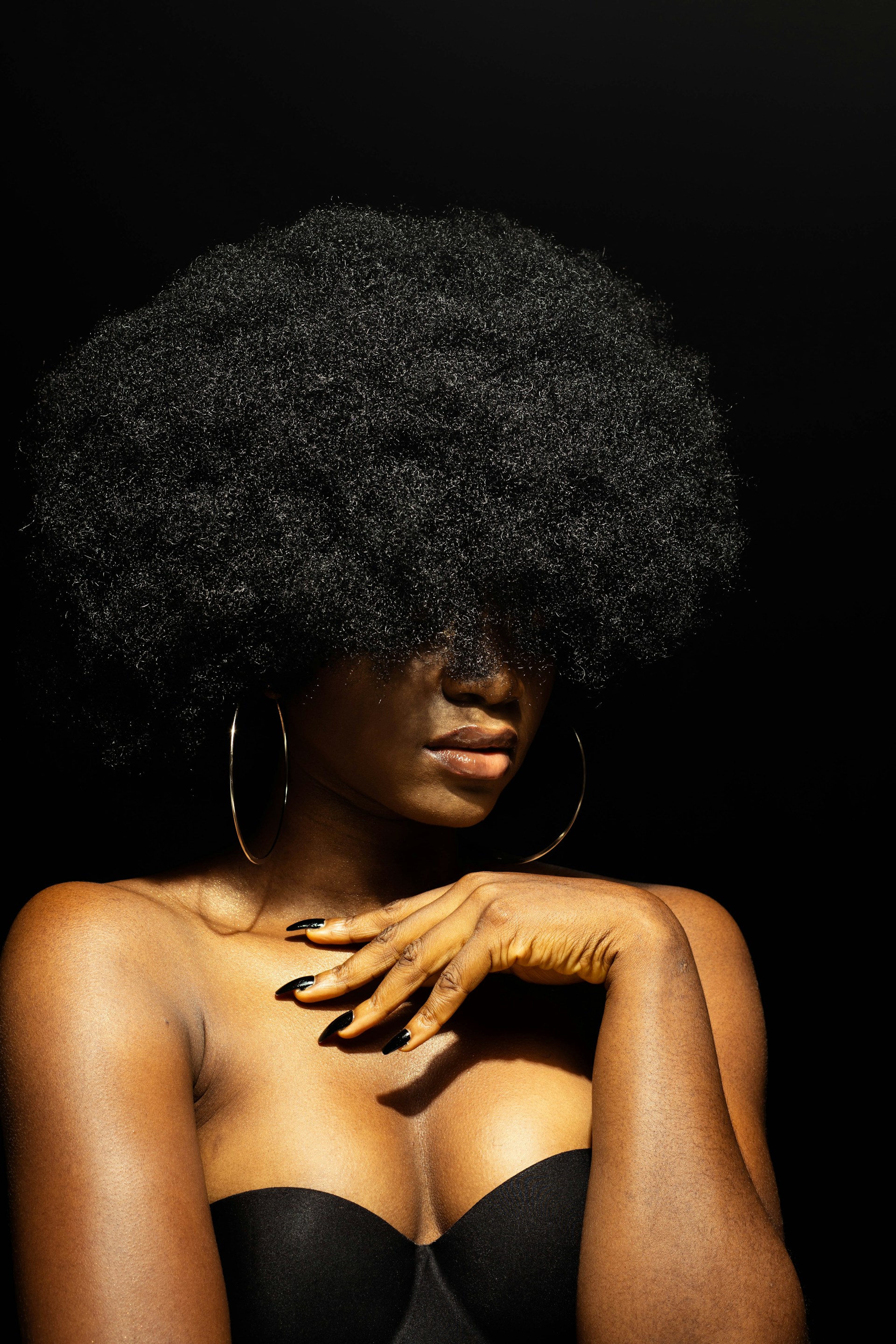 topless woman with black curly hair