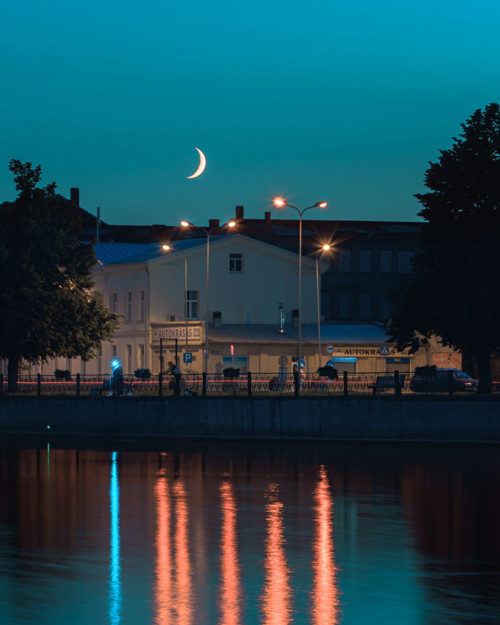 white concrete building near body of water during night time