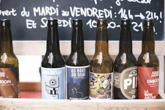 Rows of vegan beer bottles with eco-friendly labels on a wooden shelf.