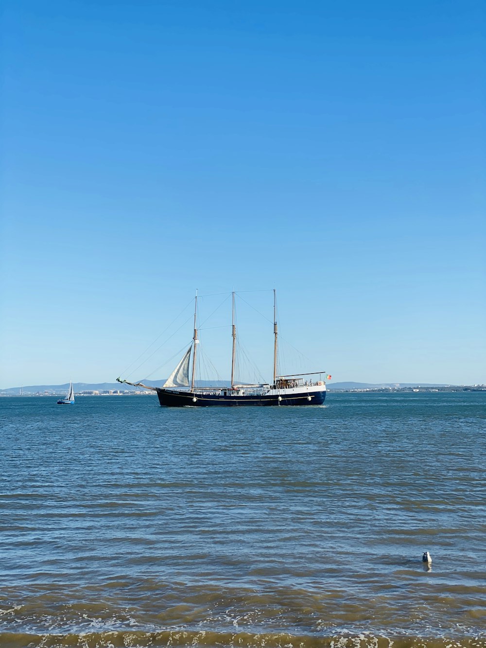 white and brown boat on sea under blue sky during daytime