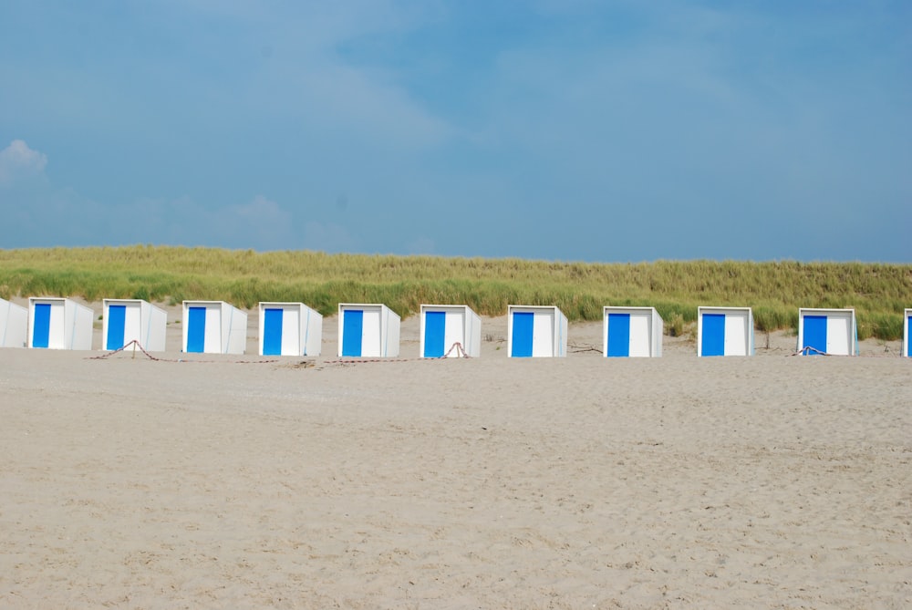 Chaises en plastique blanc sur du sable brun pendant la journée