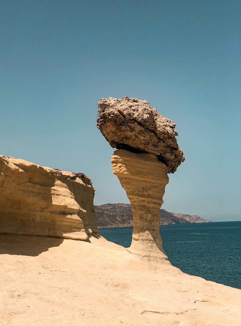 brown rock formation near body of water during daytime