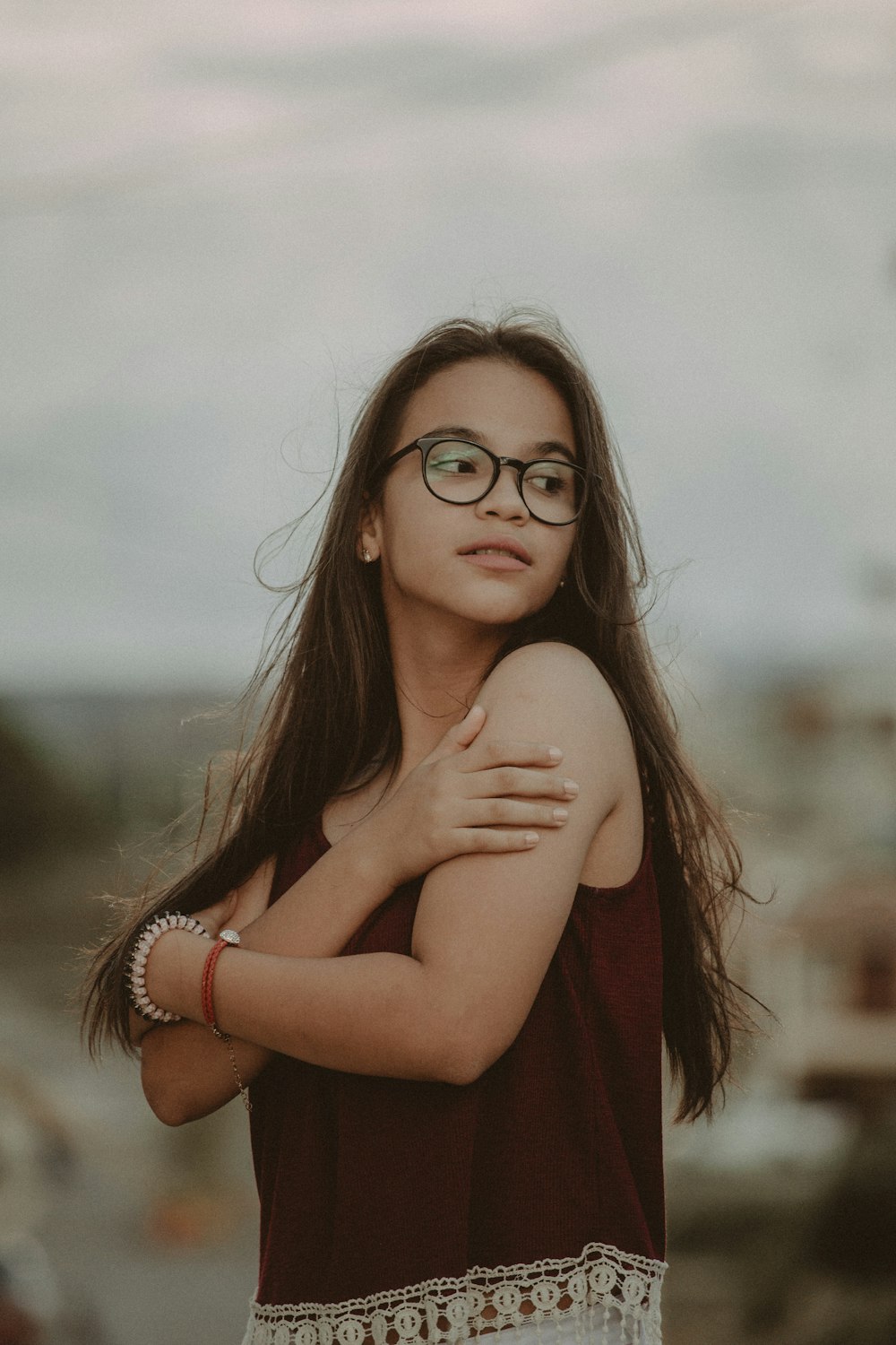 woman in red sleeveless dress wearing gold bracelet