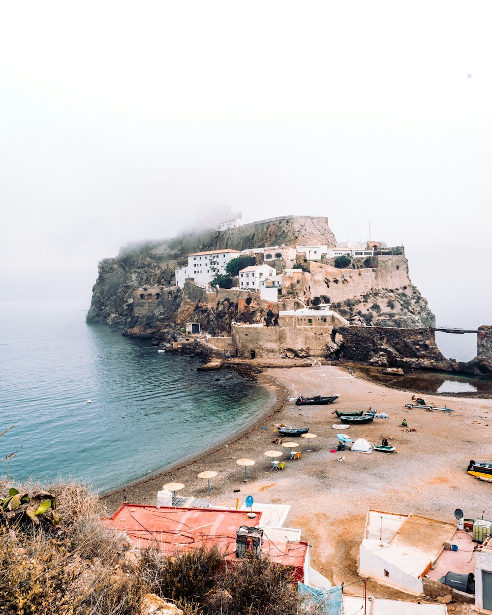 people on beach near cliff during daytime